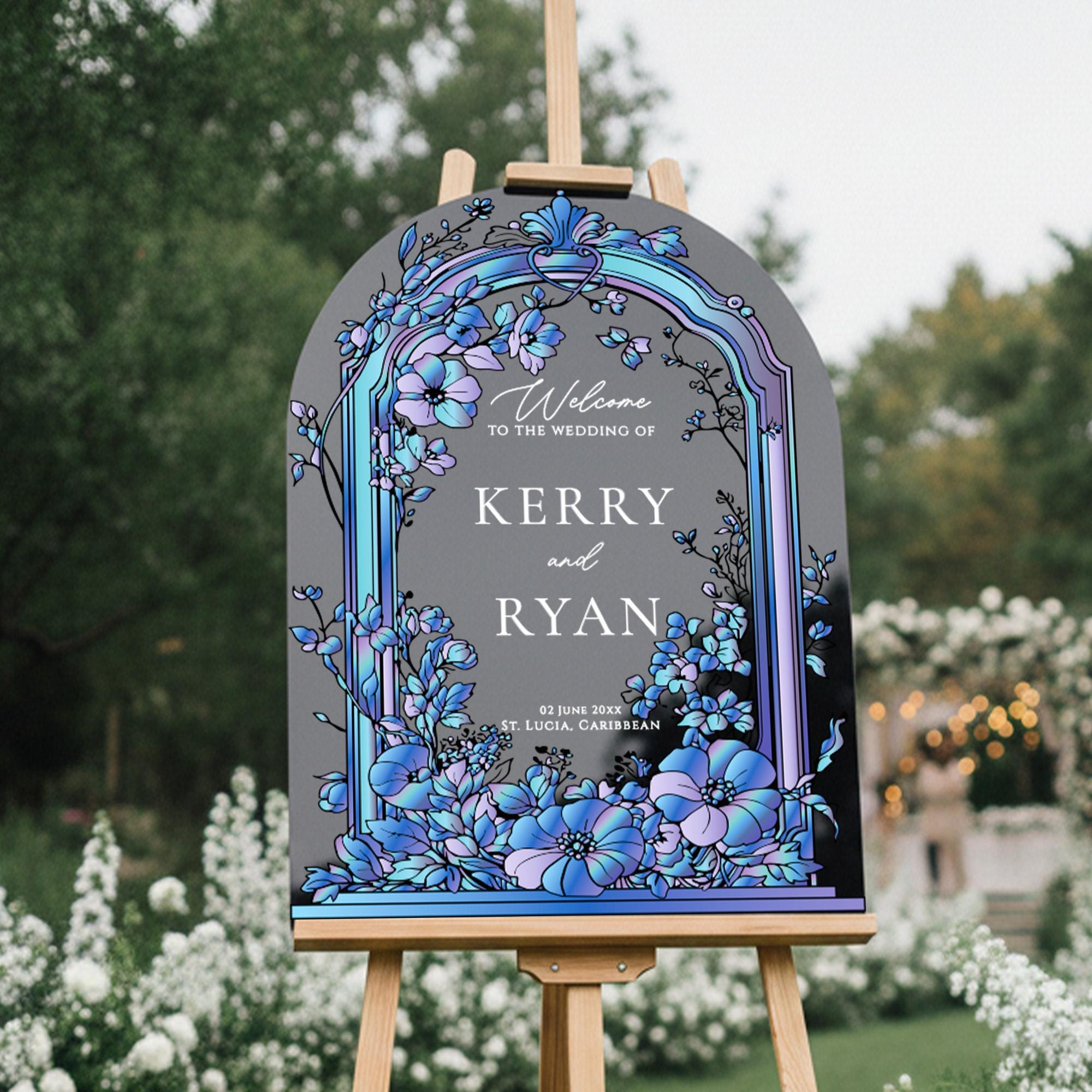 A wooden sign with a floral design and text welcoming guests to the wedding of Kerry and Ryan.