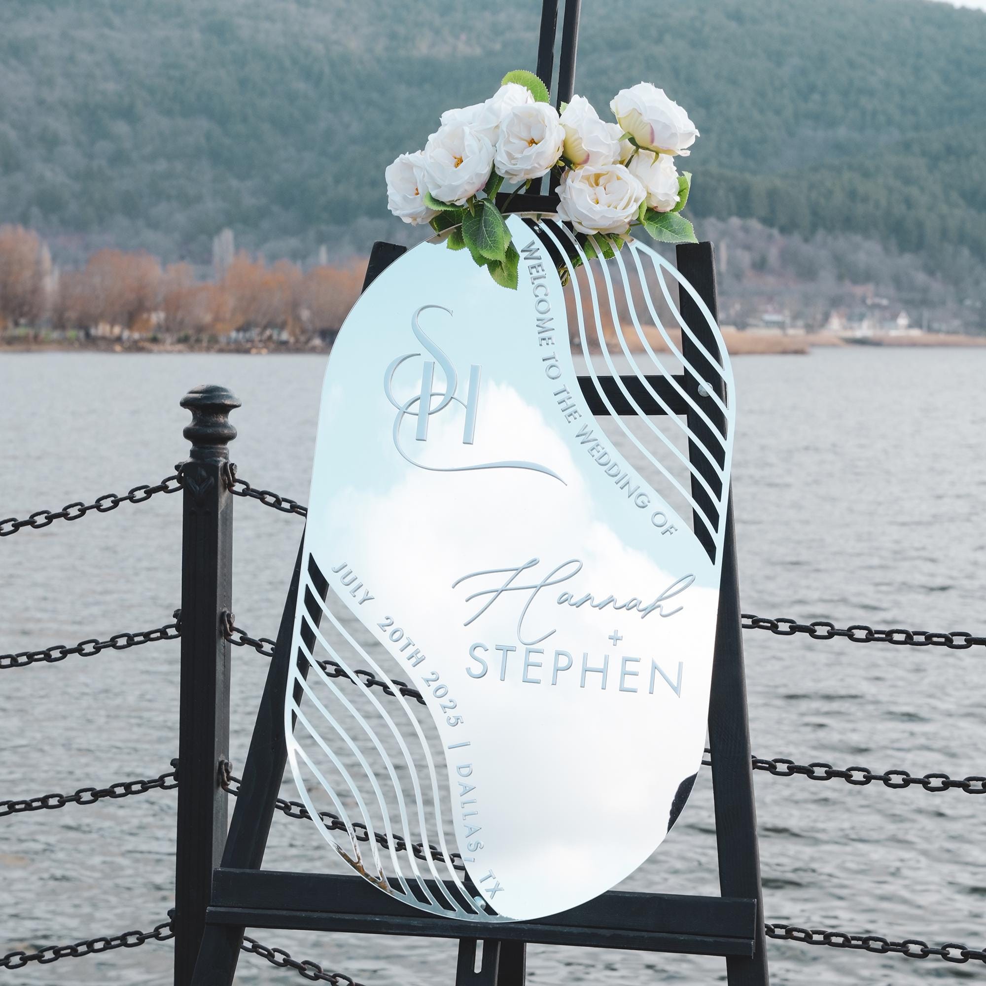 Elegant silver mirror acrylic wedding welcome sign with modern abstract cutout details and sophisticated 3D lettering. Featuring the couple’s names and wedding date, this contemporary and luxurious design adds a stylish and personalized touch to any wedding entrance.