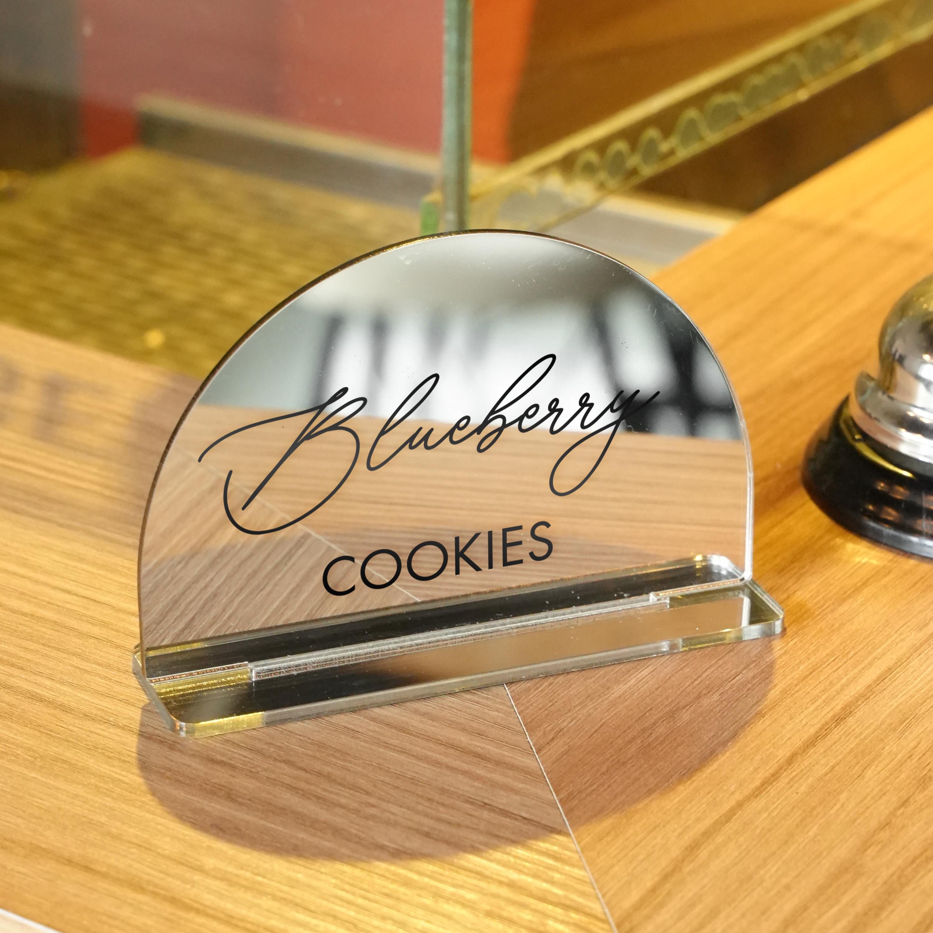 a wooden table topped with a cookie and a bell