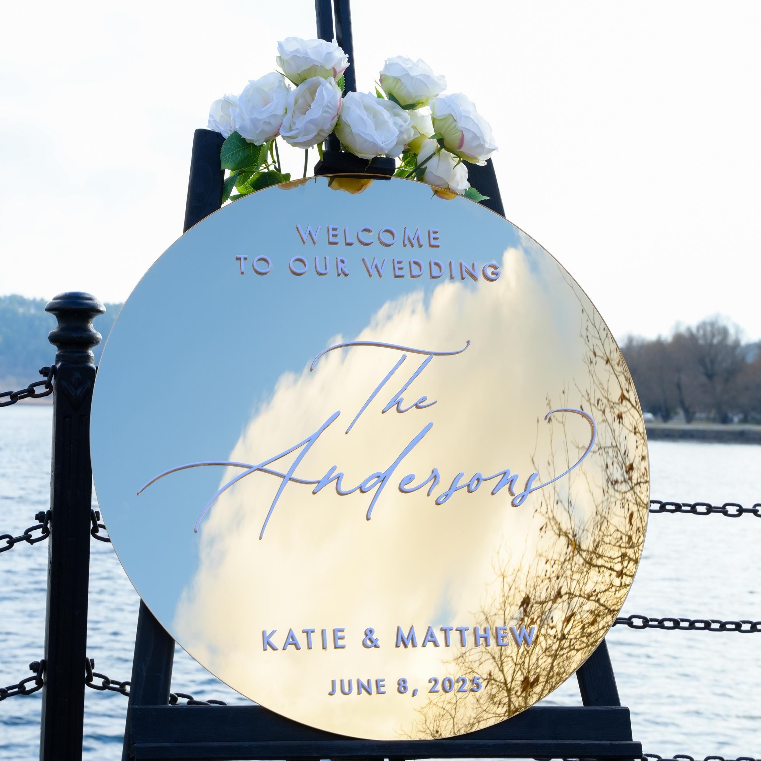 Elegant round gold mirror acrylic wedding welcome sign with stylish 3D lettering, featuring the couple’s names and wedding details. The reflective surface and modern design add a luxurious and sophisticated touch to any wedding entrance.