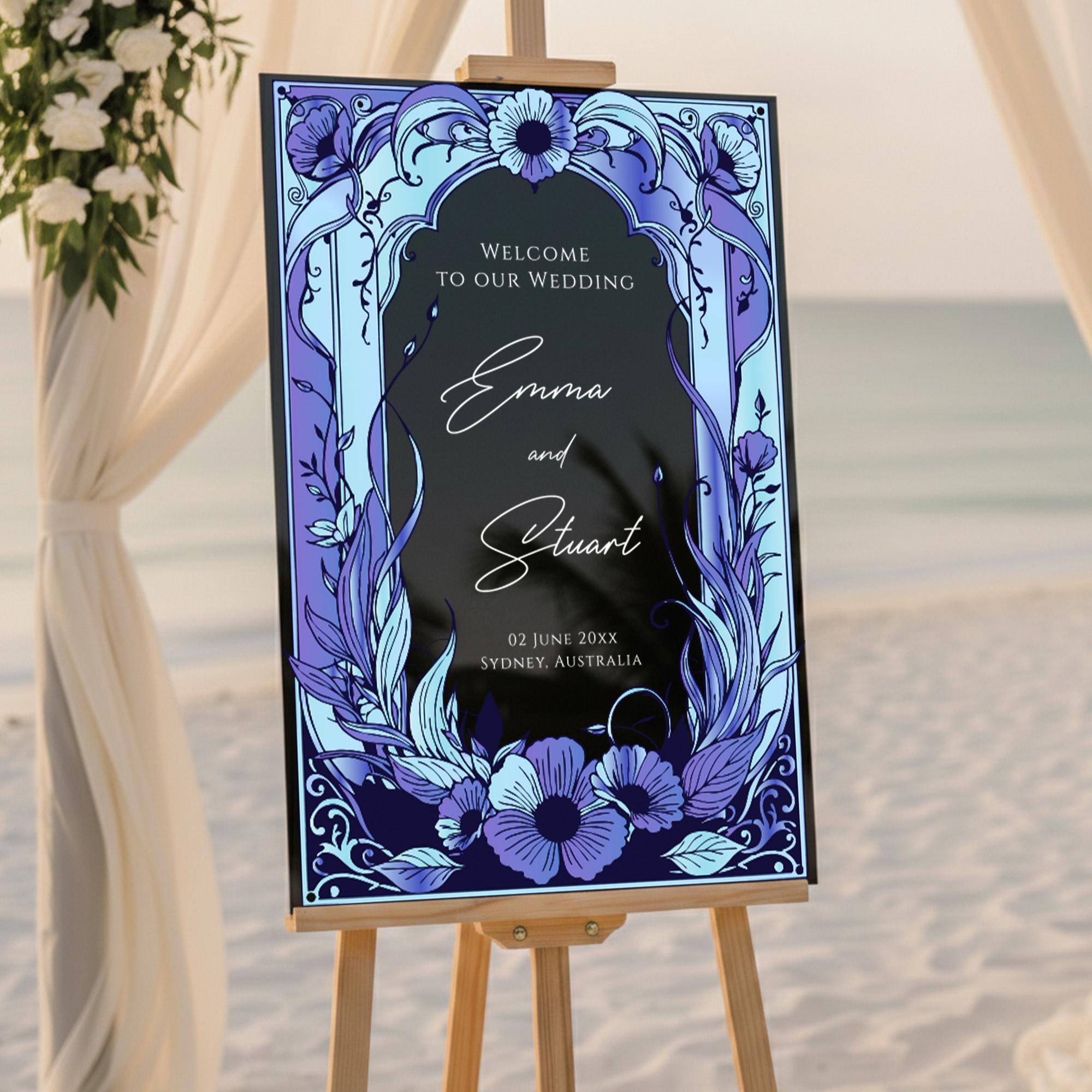 A wedding welcome sign with a floral design and text welcoming guests to the wedding of Emma and Stuart.
