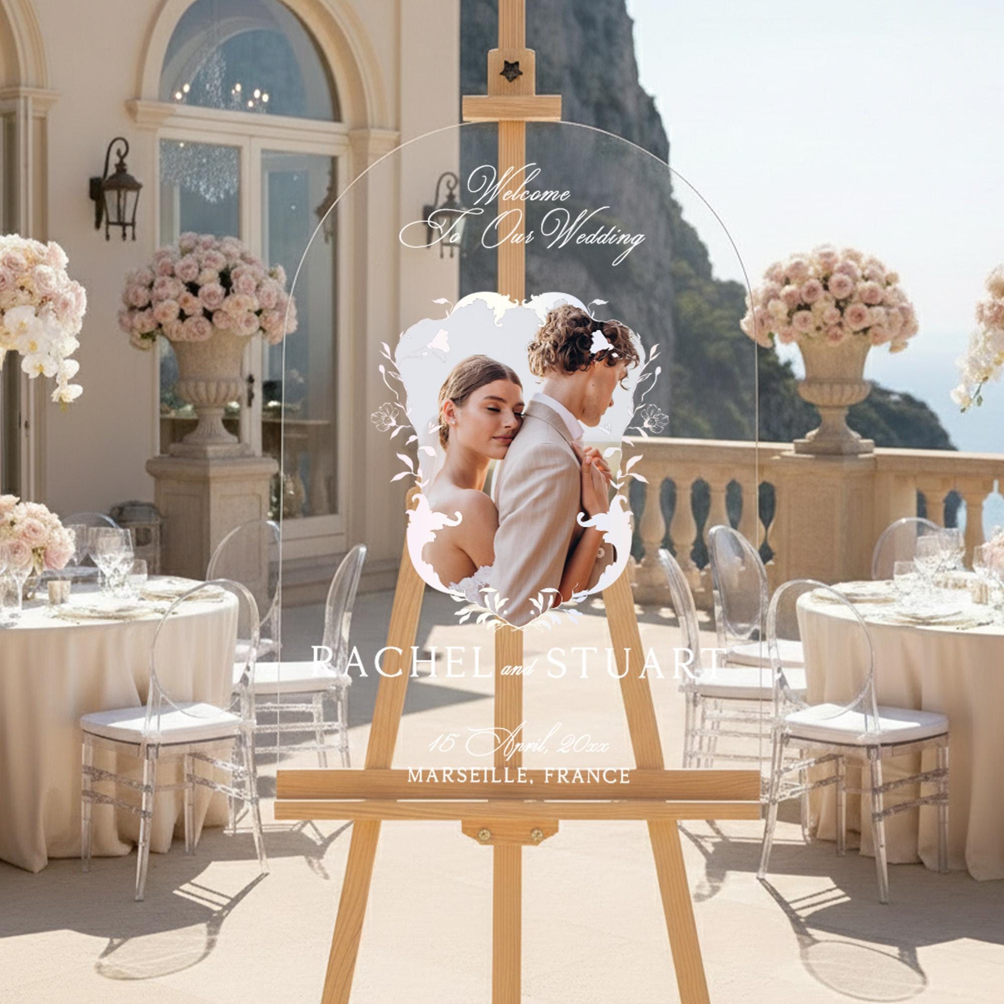 The image is a wedding invitation featuring a couple embracing in a romantic setting, with a scenic backdrop of a cliff and ocean.