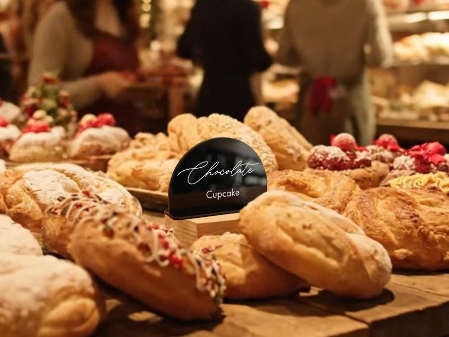 A display of various baked goods, including cakes and pastries, in a bakery setting.