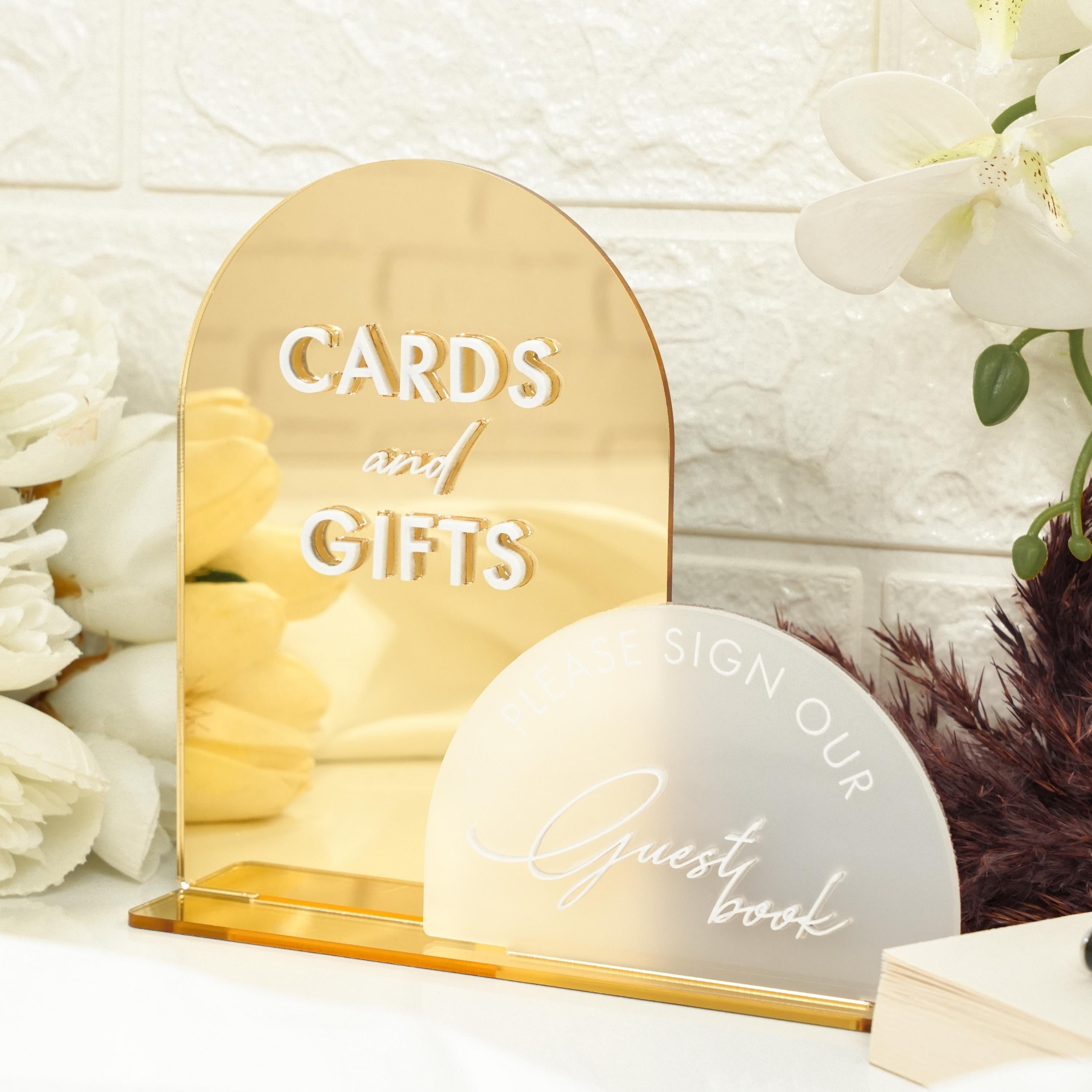 a table with a vase of flowers and cards and gifts