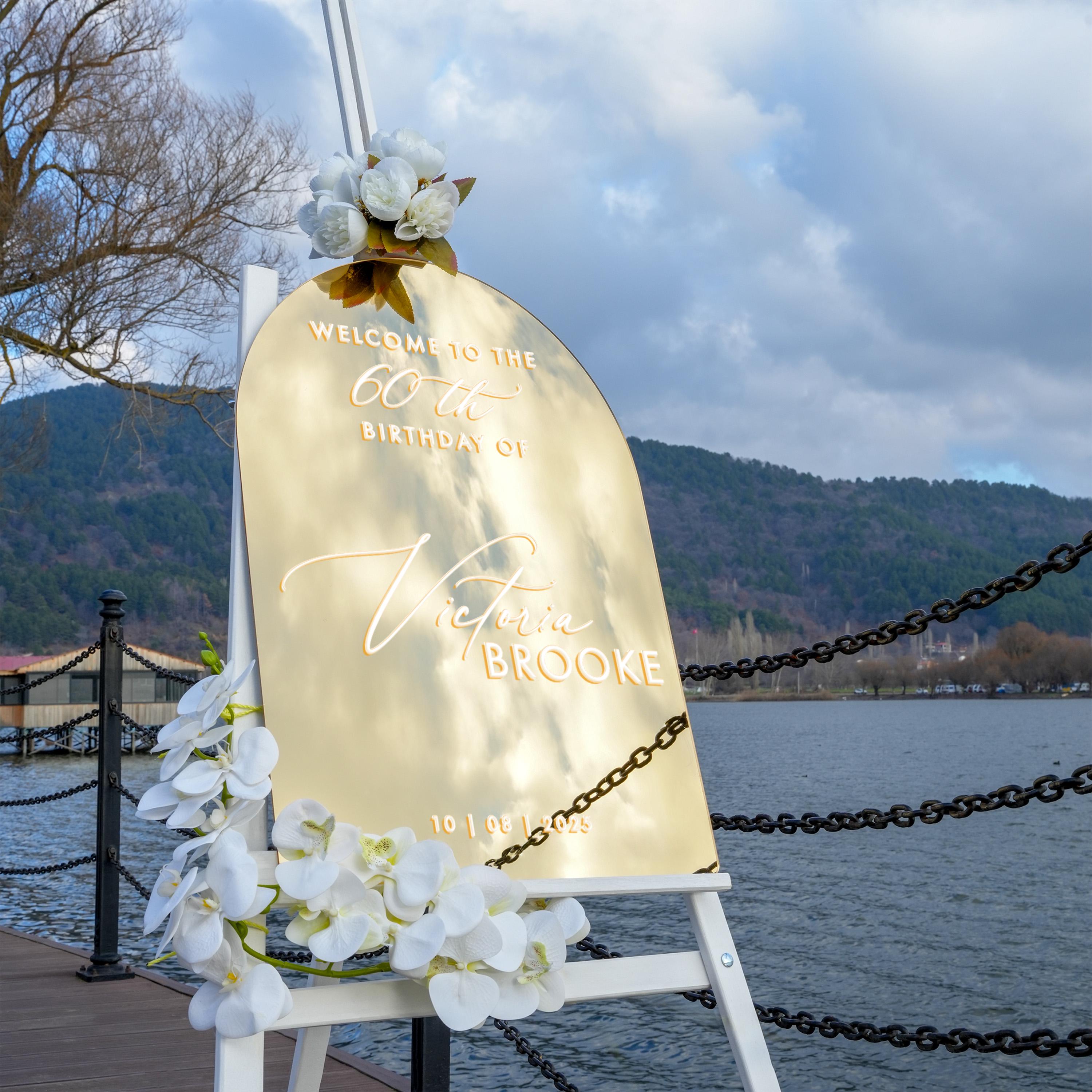 a golden sign welcoming guests to a 60th birthday celebration.