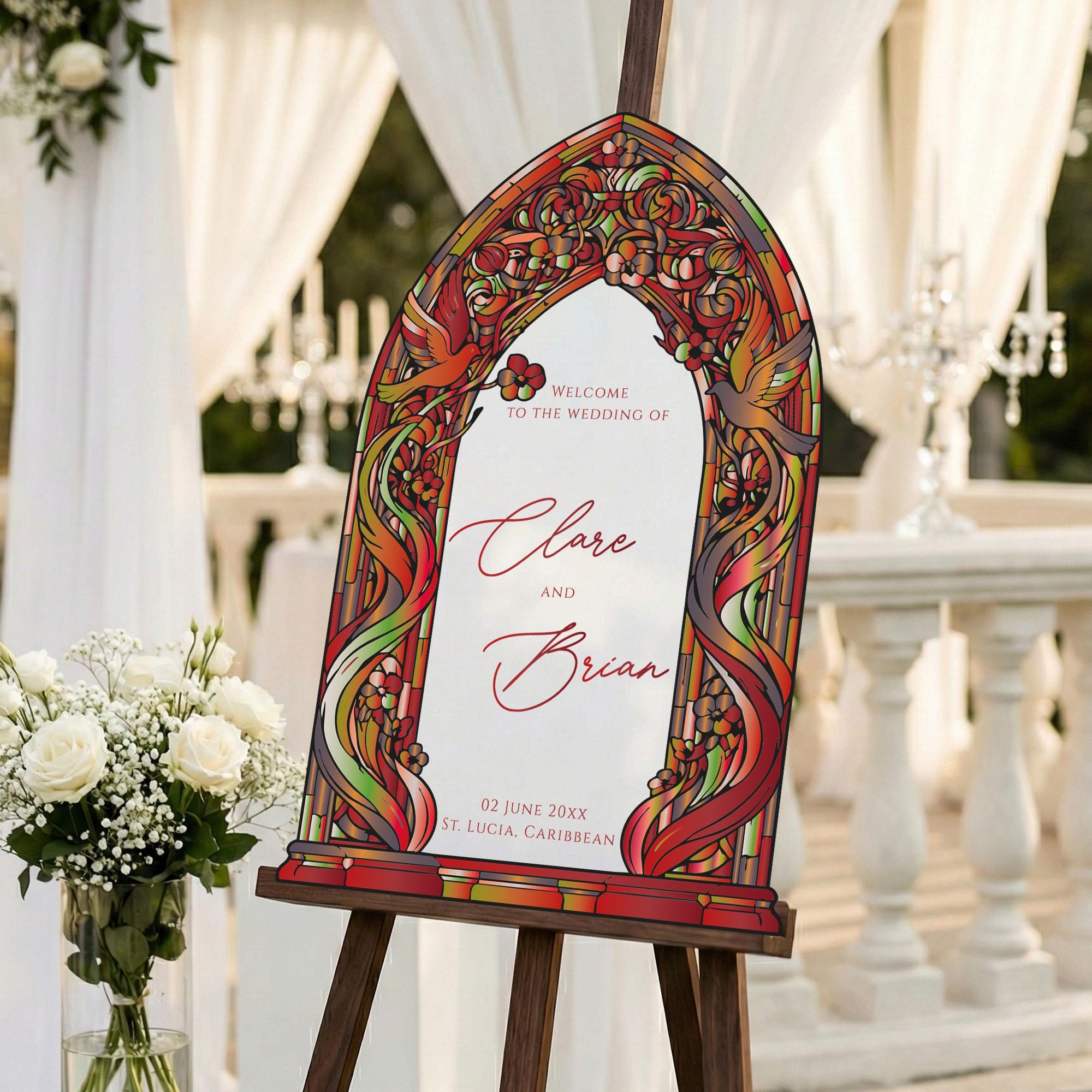 a colorful wedding invitation sign with a stained glass design, placed on a wooden stand in a garden setting.