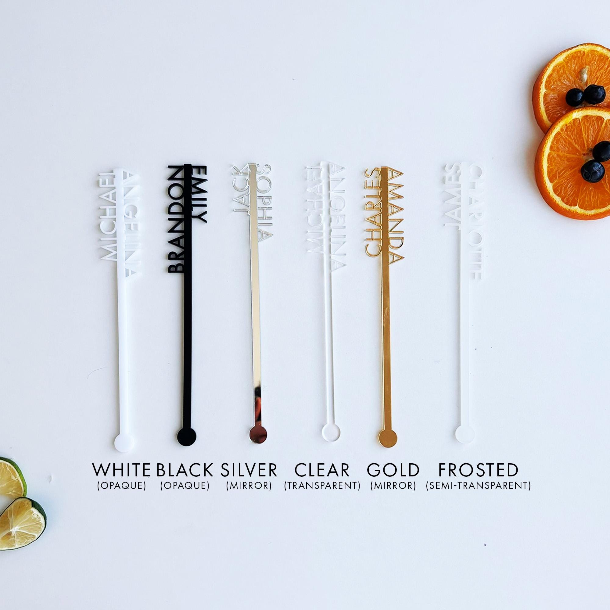 a white table topped with orange slices and black and white stirrers