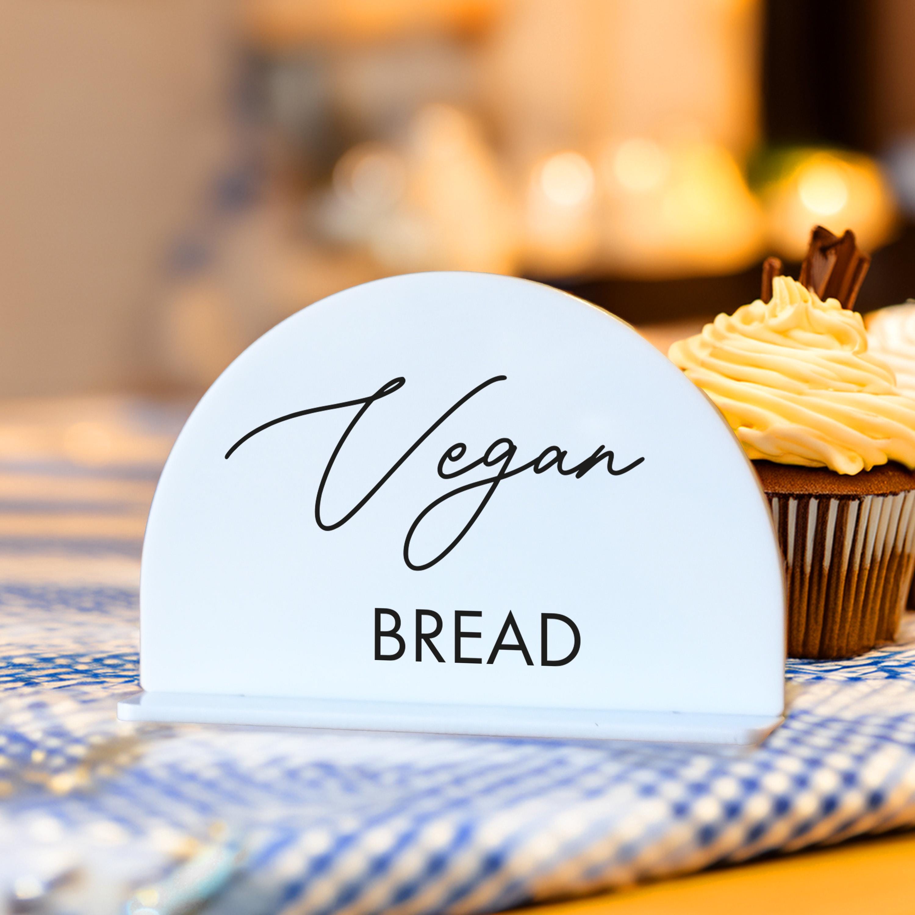 a cupcake sitting on top of a table next to a sign