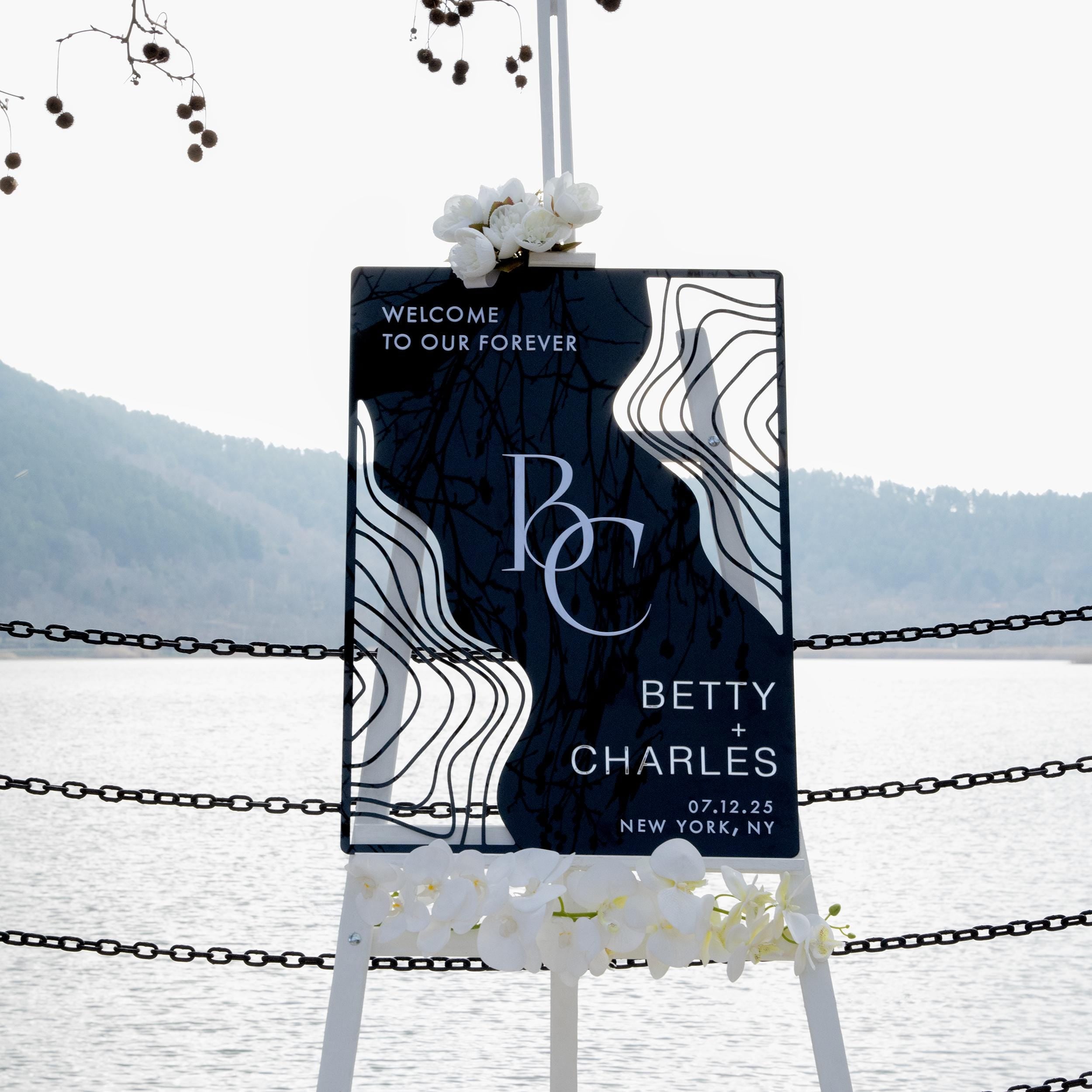 Boho black acrylic wedding welcome sign with striking 3D lettering, featuring the couple’s initials, names, and wedding date. The sleek design and artistic wavy accents create a stylish, contemporary focal point at any wedding entrance.