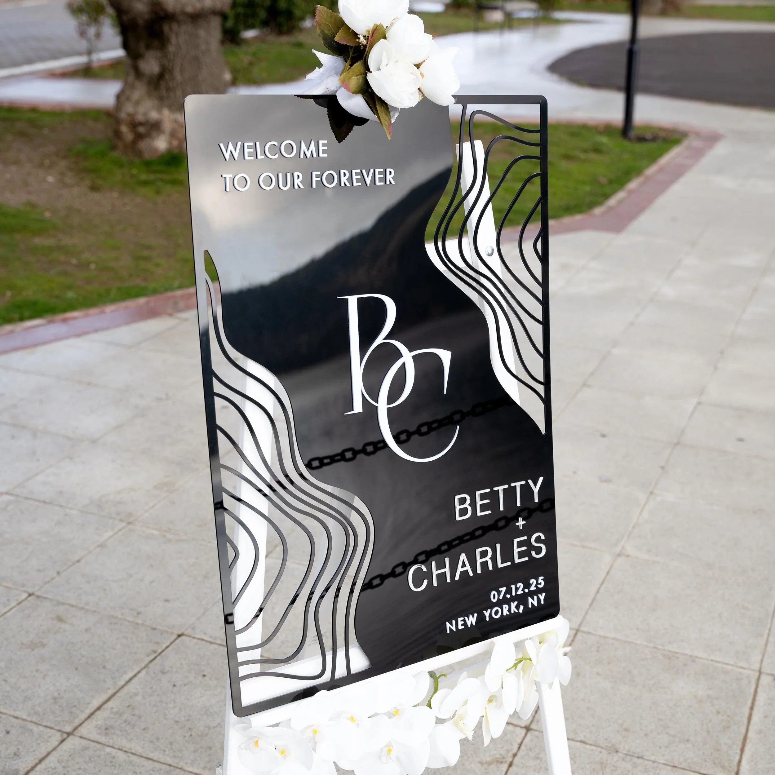 Boho black acrylic wedding welcome sign with striking 3D lettering, featuring the couple’s initials, names, and wedding date. The sleek design and artistic wavy accents create a stylish, contemporary focal point at any wedding entrance.