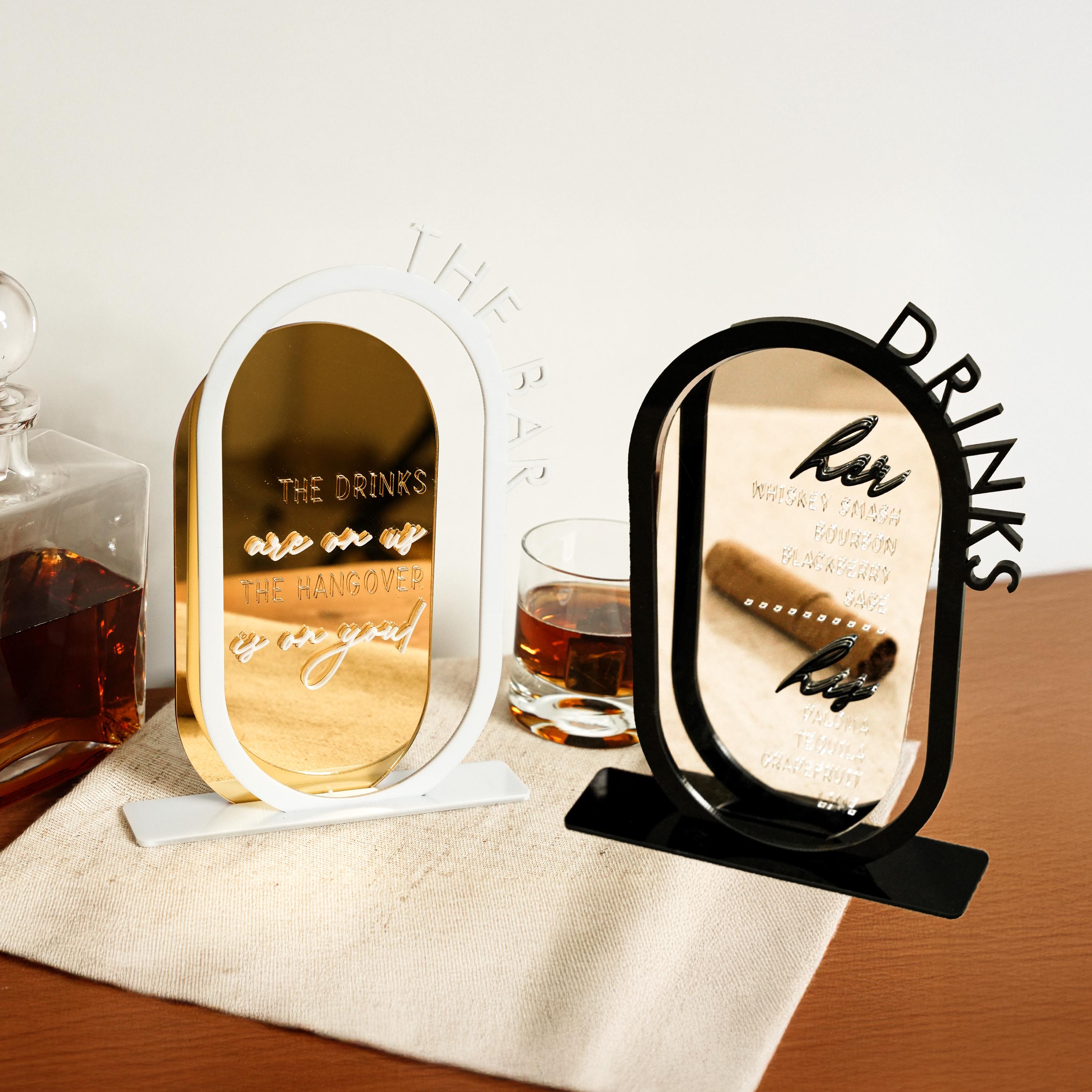 a wooden table topped with a bottle of alcohol and a mirror