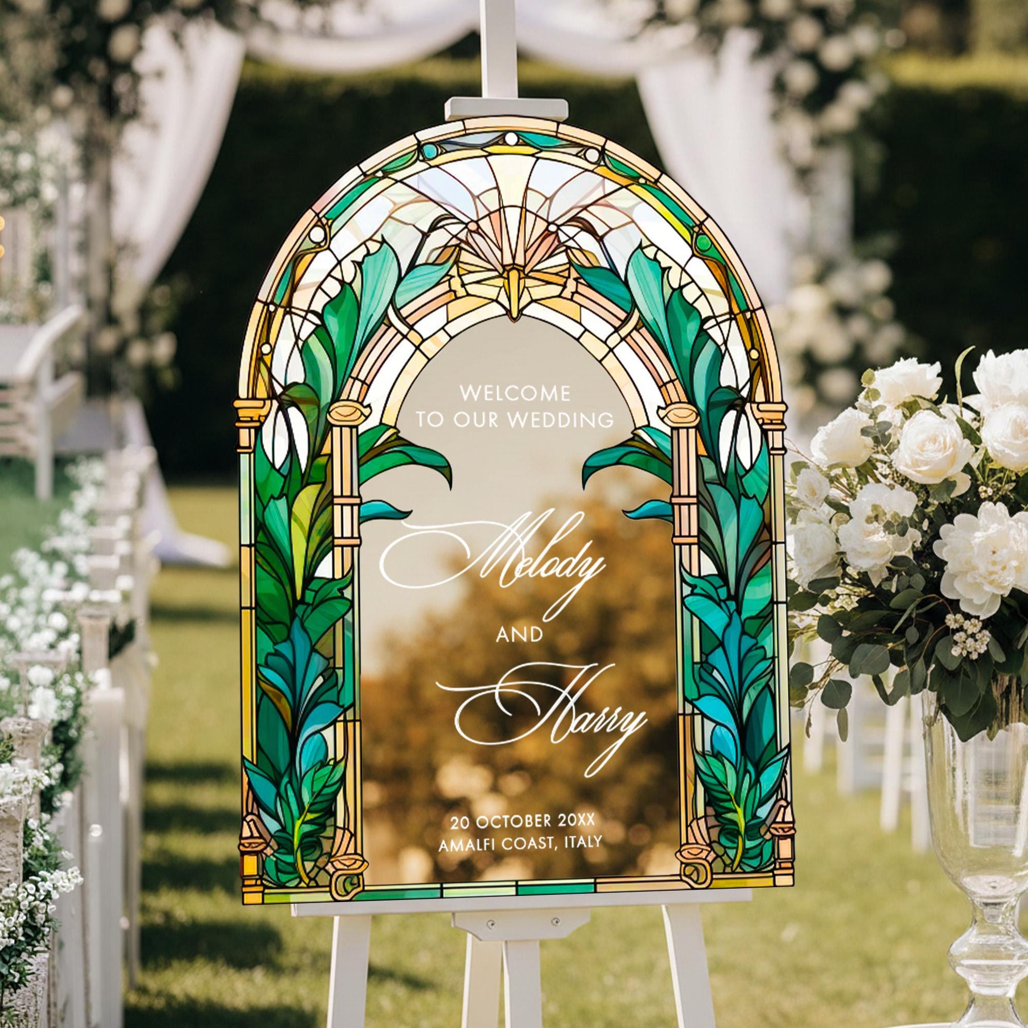 A white wedding sign with a stained glass design, displaying the names "Molly and Harry" and the date "20 October 2019 AMALFI Coast, Italy".