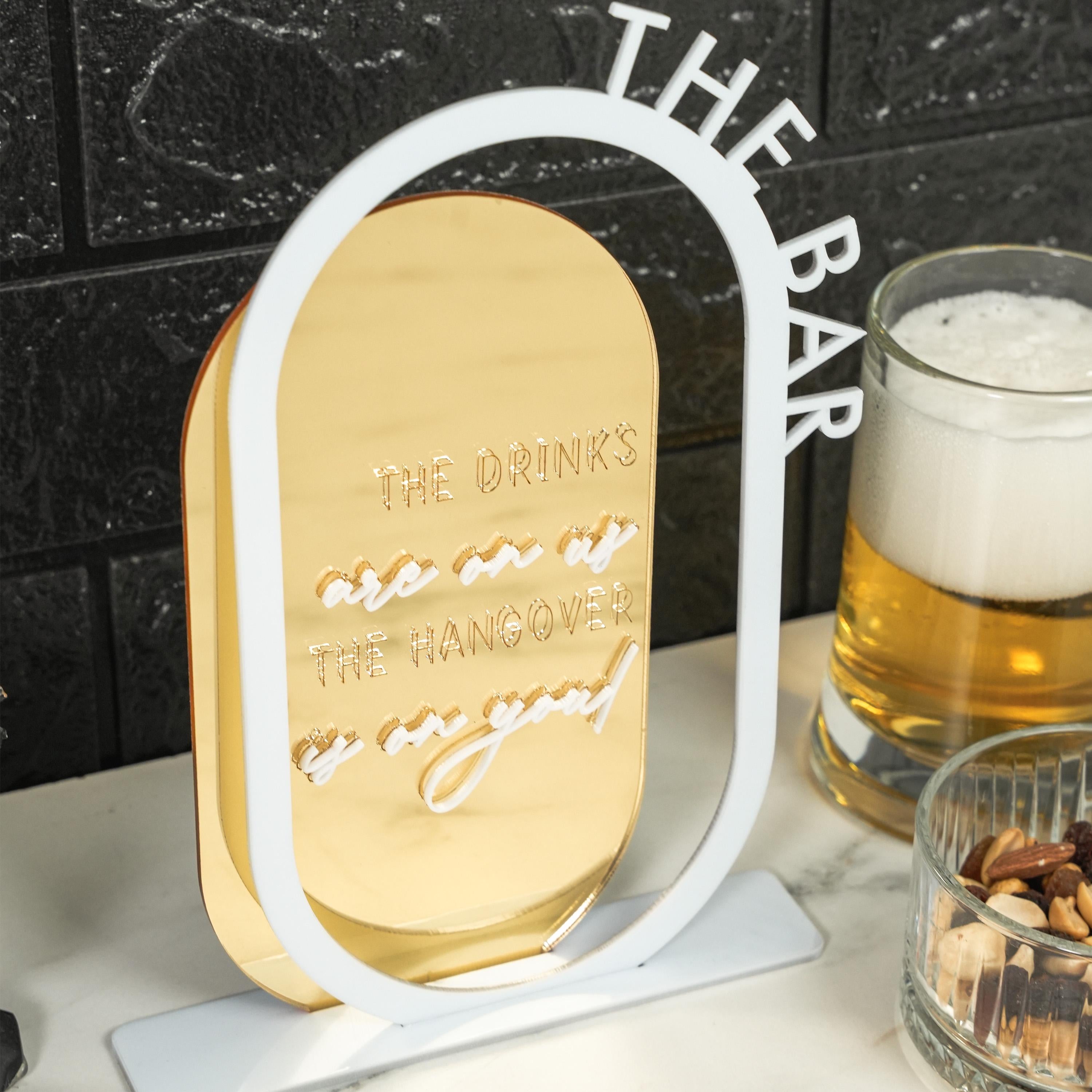 a glass of beer sitting next to a metal sign