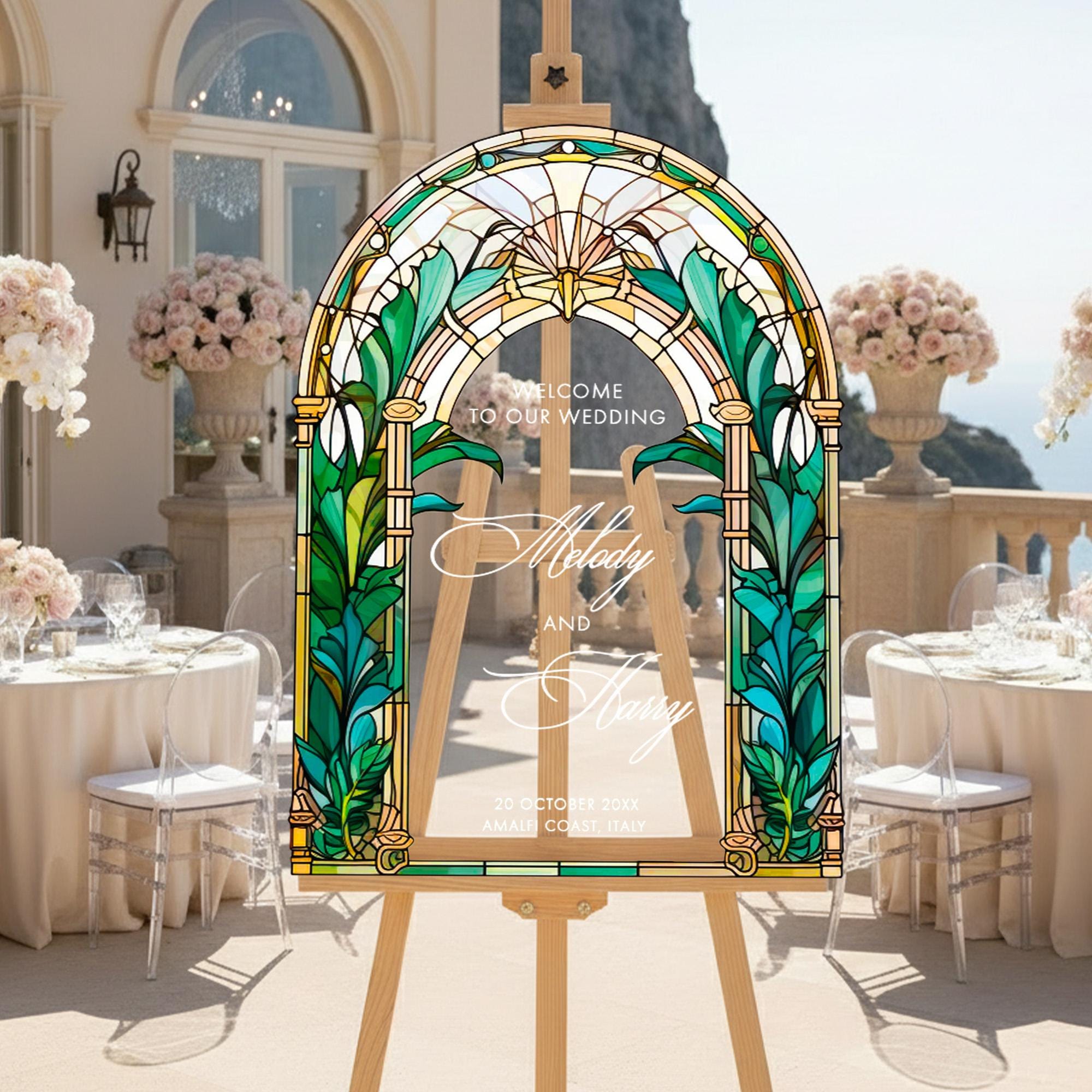 a wedding invitation with a stained glass design, placed on a wooden easel in a setting with tables and chairs.