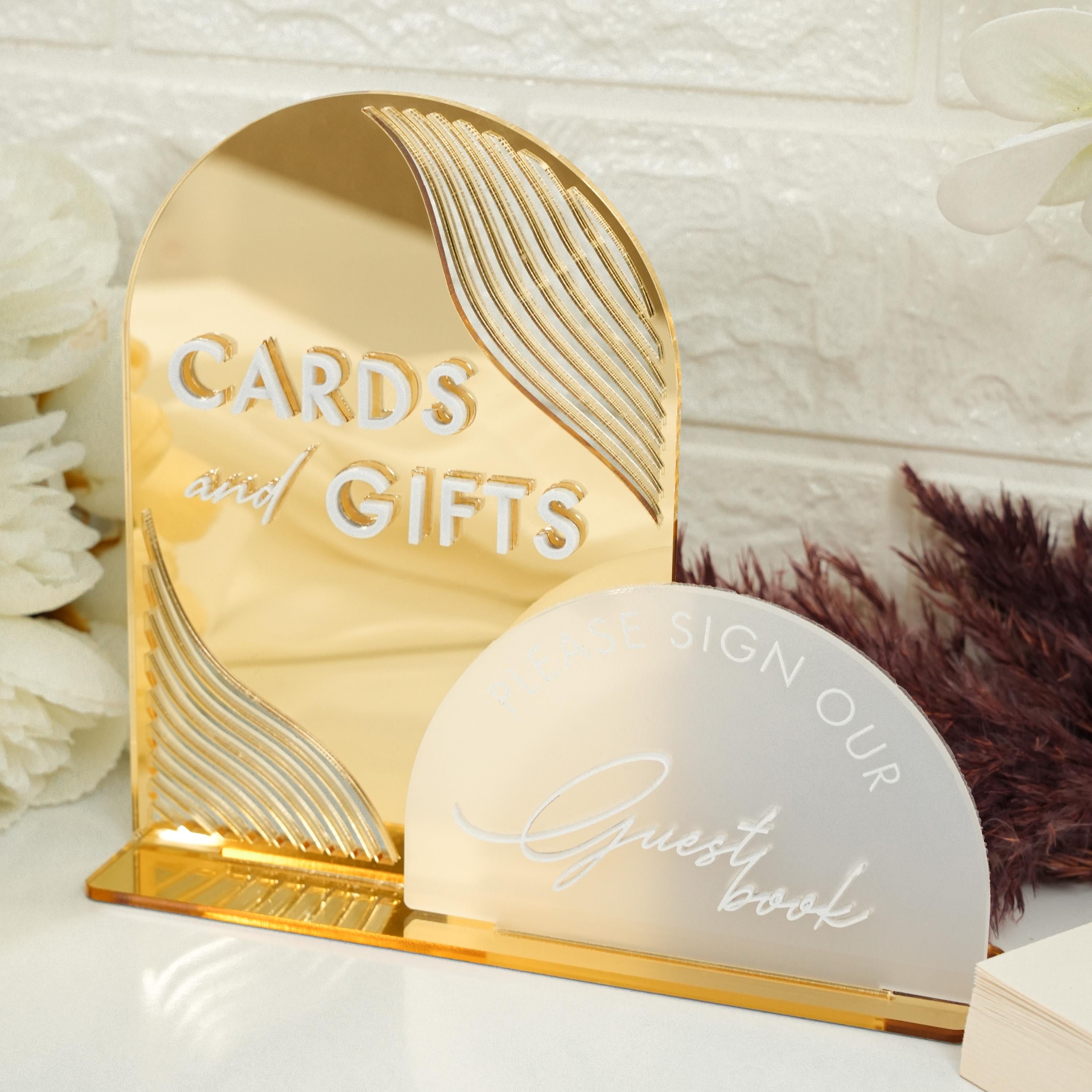 a gold card and gift box sitting on a table