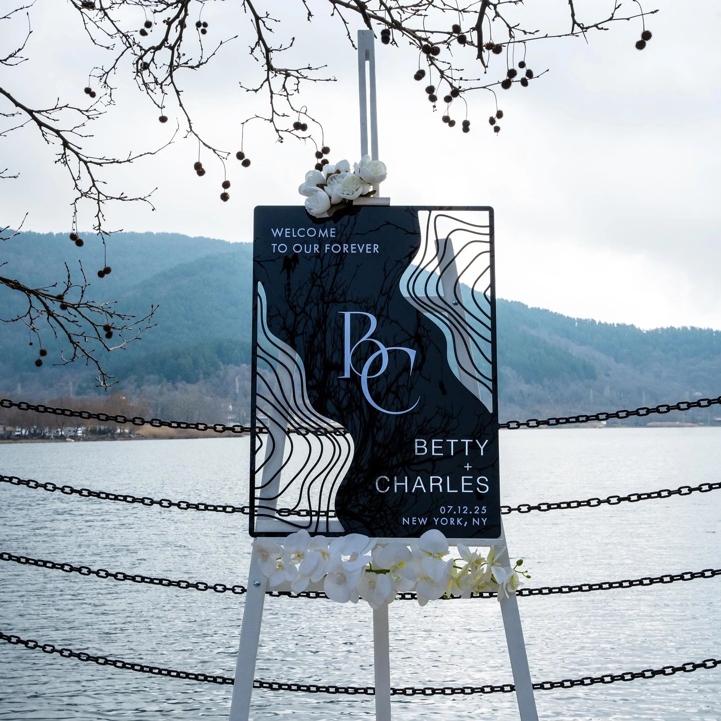 Boho black acrylic wedding welcome sign with striking 3D lettering, featuring the couple’s initials, names, and wedding date. The sleek design and artistic wavy accents create a stylish, contemporary focal point at any wedding entrance.