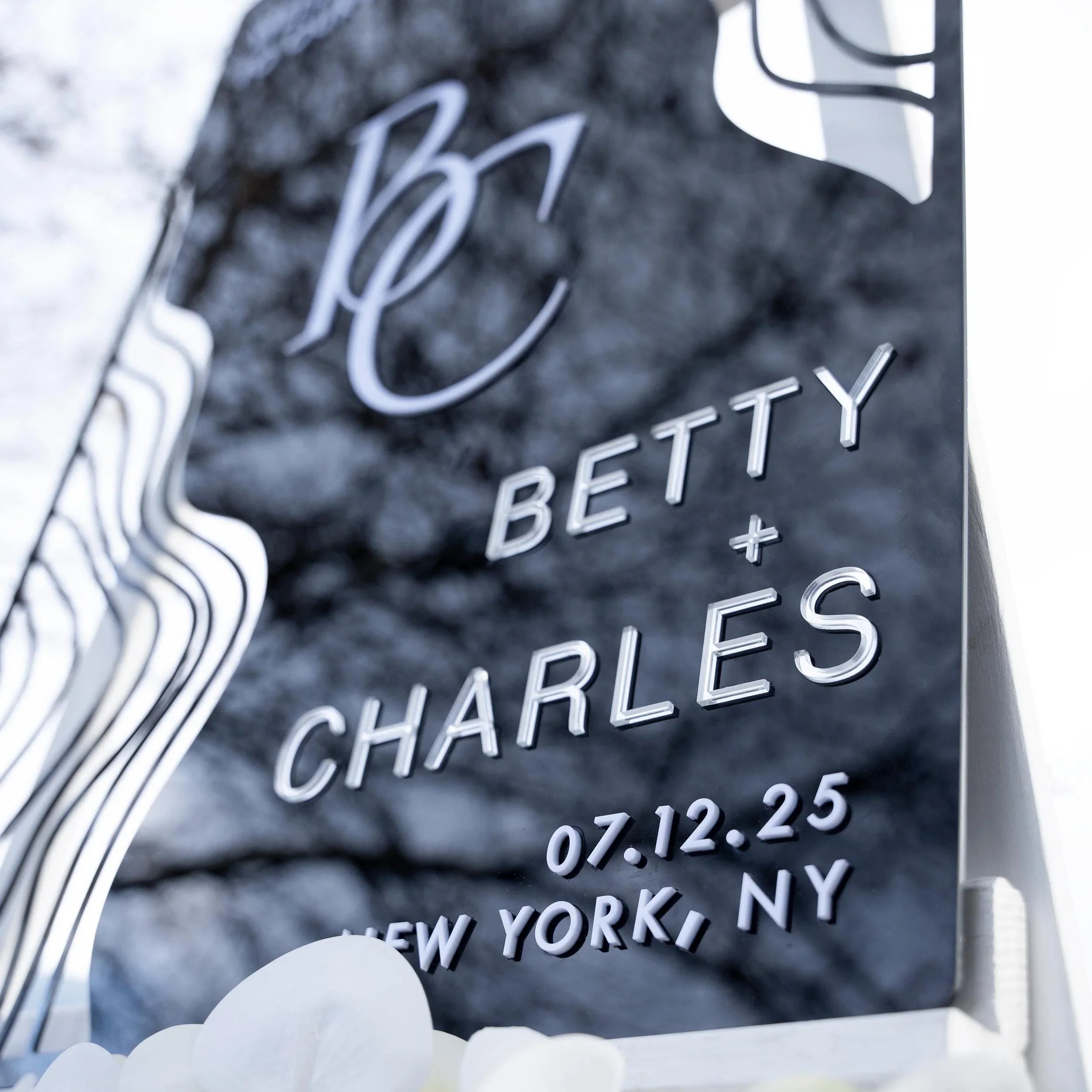 Boho black acrylic wedding welcome sign with striking 3D lettering, featuring the couple’s initials, names, and wedding date. The sleek design and artistic wavy accents create a stylish, contemporary focal point at any wedding entrance.